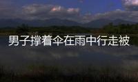 男子撐著傘在雨中行走被閃電擊中 地面火花四濺猶如電影特效